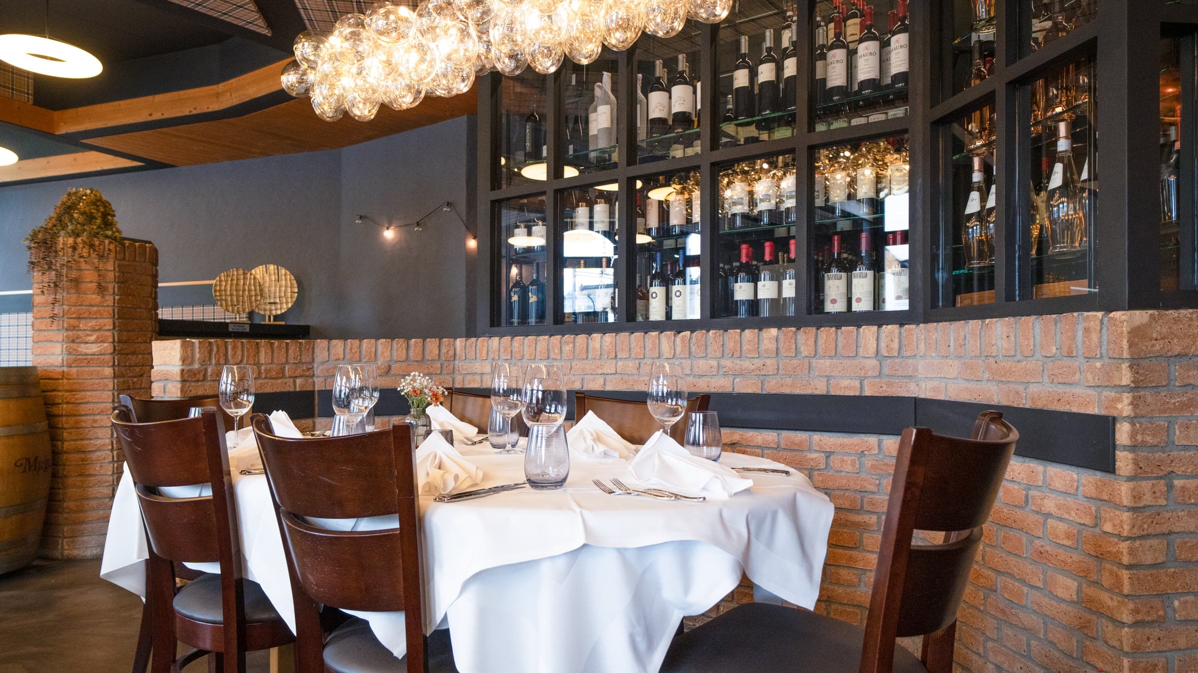 Ein gedeckter Tisch vor der Weinwand des Gastraums